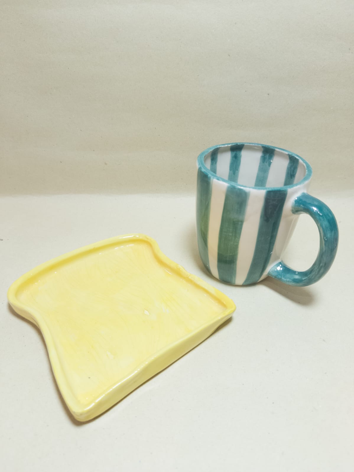 Taza rayada verde con plato tostada